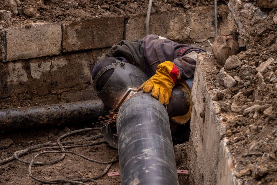 Close-up of drainage pipe being inspected with tools in a Truro garden